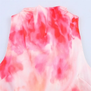 Detailed close-up of a tie-dye satin midi dress with vibrant red and pink watercolor patterns
