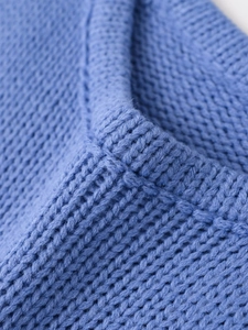 Close-up of royal blue knit sweater showing detailed chunky V-pattern texture and soft yarn