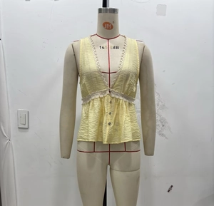 Detailed view of yellow V-neck sleeveless top with lace trim and natural crinkle texture