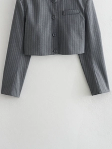 Detail view of grey pinstriped cropped blazer with buttons and chest pocket