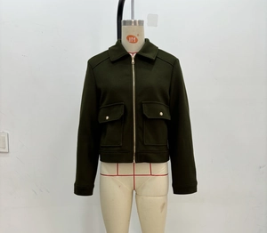 Detail of dark green zipper jacket showing flap pockets and textured wool blend fabric