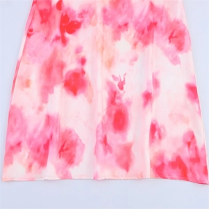 Close-up of pink tie-dye satin midi dress fabric with smooth texture and clean hemline