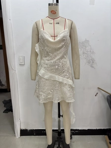 Detail of white sequin cocktail dress featuring a cowl neck and ruffled side pleats