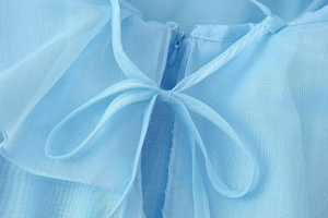 Detail view of light blue tulle dress with invisible zipper and elegant tie-back bow