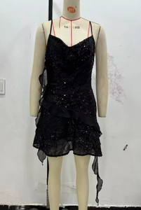 Detail of black sequined mini dress featuring ruffled mesh hem and tiered embellishments