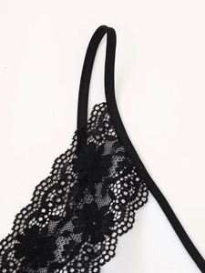Close-up of intricate black floral lace trim and delicate strap on a women dress