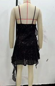 Macro view of black sequined evening dress with layered chiffon ruffles and lace hem
