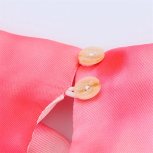Detail of pink tie-dye satin midi dress with amber buttons and elastic loop closure