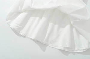 Detail of the high-quality double-stitched hem and white fabric texture on this dress