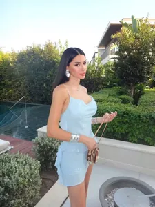Close-up of light blue sequined mini dress featuring a cowl neck and side ruffles