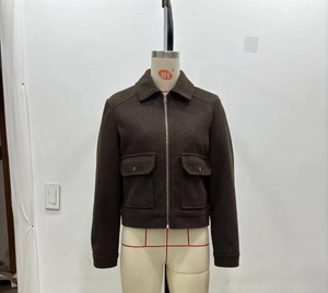 Detail of dark brown wool jacket featuring metal zipper and symmetrical cargo chest pockets