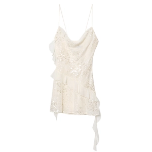 Detail of white sequin slip dress featuring a cowl neck and ruffled chiffon trim