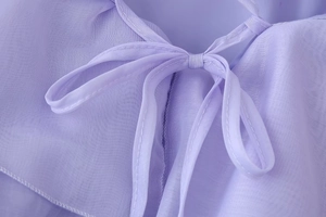 Detail of lavender chiffon dress showing delicate tie-up bow and semi-transparent fabric
