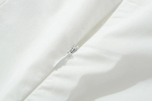 Detail shot of the high-quality invisible zipper on a white embroidered sleeveless dress