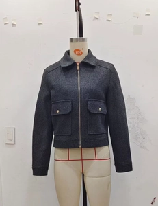 Close-up of dark grey short wool jacket with metal zipper and large chest pockets