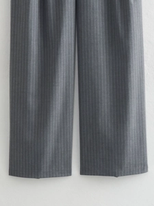 Close-up of straight leg trousers with vertical white stripes on dark grey fabric