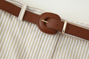 Détail d'un short rayé avec ceinture en cuir à boucle ronde et texture en coton et lin