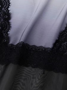 Detail of lavender silky fabric with black floral lace stitching and sheer mesh texture