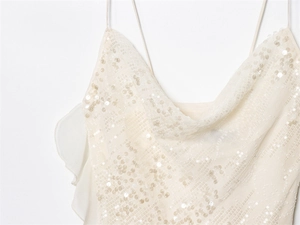Detail of cream sequined dress with thin straps, draped neckline and ruffle trim