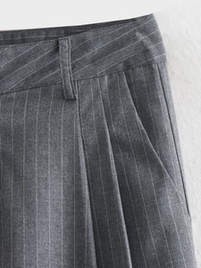 Detailed close-up of dark grey pinstripe trousers waist with belt loops and fine tailoring