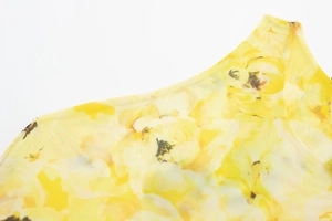 Detail of yellow floral print on semi-transparent mesh fabric with delicate mesh texture