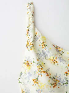 Close-up of floral print satin dress featuring elegant knot detail and vibrant patterns