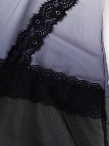 Detailed view of lilac wrinkled fabric with black floral lace and sheer mesh patchwork