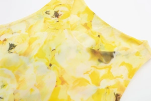 Close-up of crew neckline on a yellow floral mesh top showing sheer fabric texture