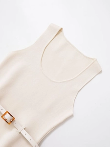 Close-up of beige sleeveless knit top featuring a white belt with tortoiseshell buckle