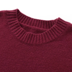 Detailed macro view of the ribbed crewneck collar on a wine red knit sweater