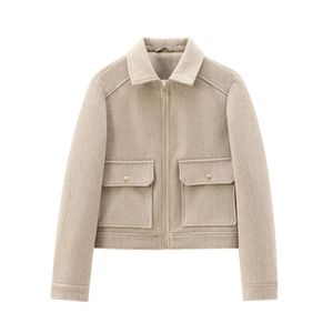 Detail of oatmeal short jacket with gold zippers and large pockets on white background