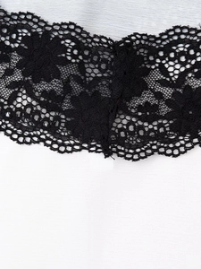 Detailed macro view of delicate black floral lace contrast on white fabric hem