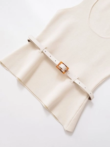 Detail of cream sleeveless knitwear with slim belt and amber resin buckle texture