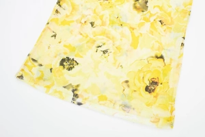 Close-up detail of yellow floral print on breathable mesh fabric for women dress