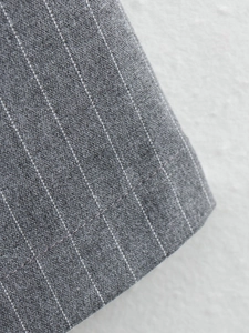 Macro shot of grey pinstripe fabric showing fine stitching and premium textile texture