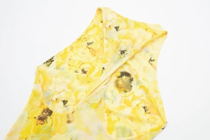 Detail of yellow floral print fabric with a layered neckline on a sheer mesh dress