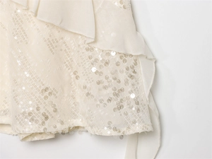 Detailed macro view of sequin embellishments and layered ruffle trim on summer dress