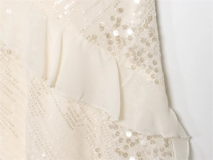 Detail of cream chiffon fabric featuring wave ruffles and tone-on-tone sequins