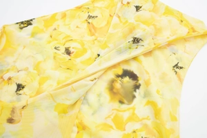 Detailed macro view of yellow floral print on breathable sheer mesh fabric material