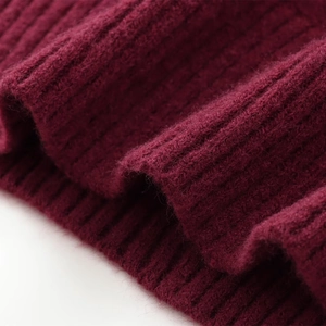 Detailed macro view of the soft burgundy ribbed knit fabric texture on a long sleeve sweater