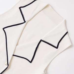 Sleeveless knit vest with contrast trim, classic turn-down collar and gold button detail