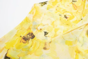 Close-up of bright yellow floral print on breathable sheer mesh fabric for women's dress