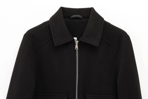 Detail of black wool-blend jacket with silver metal zipper and classic turnover collar