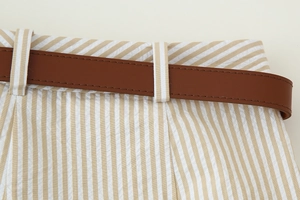 Détail de la taille en seersucker rayé avec une fine ceinture en cuir marron pour femmes
