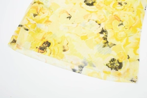 Close-up of yellow floral pattern on semi-transparent mesh fabric with clean stitching
