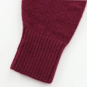 Detail of ribbed cuff on dark red knitted sweater with soft brushed texture finish