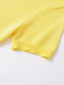 Close-up of vibrant yellow knit sweater featuring ribbed cuffs and fine textile texture
