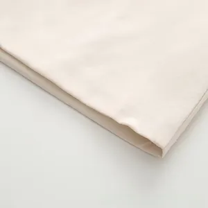 Gros plan détaillé montrant les coutures de qualité sur l'ourlet en tissu beige crème