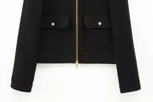 Detail of black wool jacket featuring silver metal zipper and symmetrical flap pockets