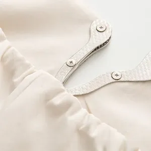Vue détaillée de la boucle en métal à motif diamant avec vis sur la robe en strass